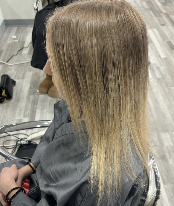 Straight, blonde, shoulder-length hair in salon.