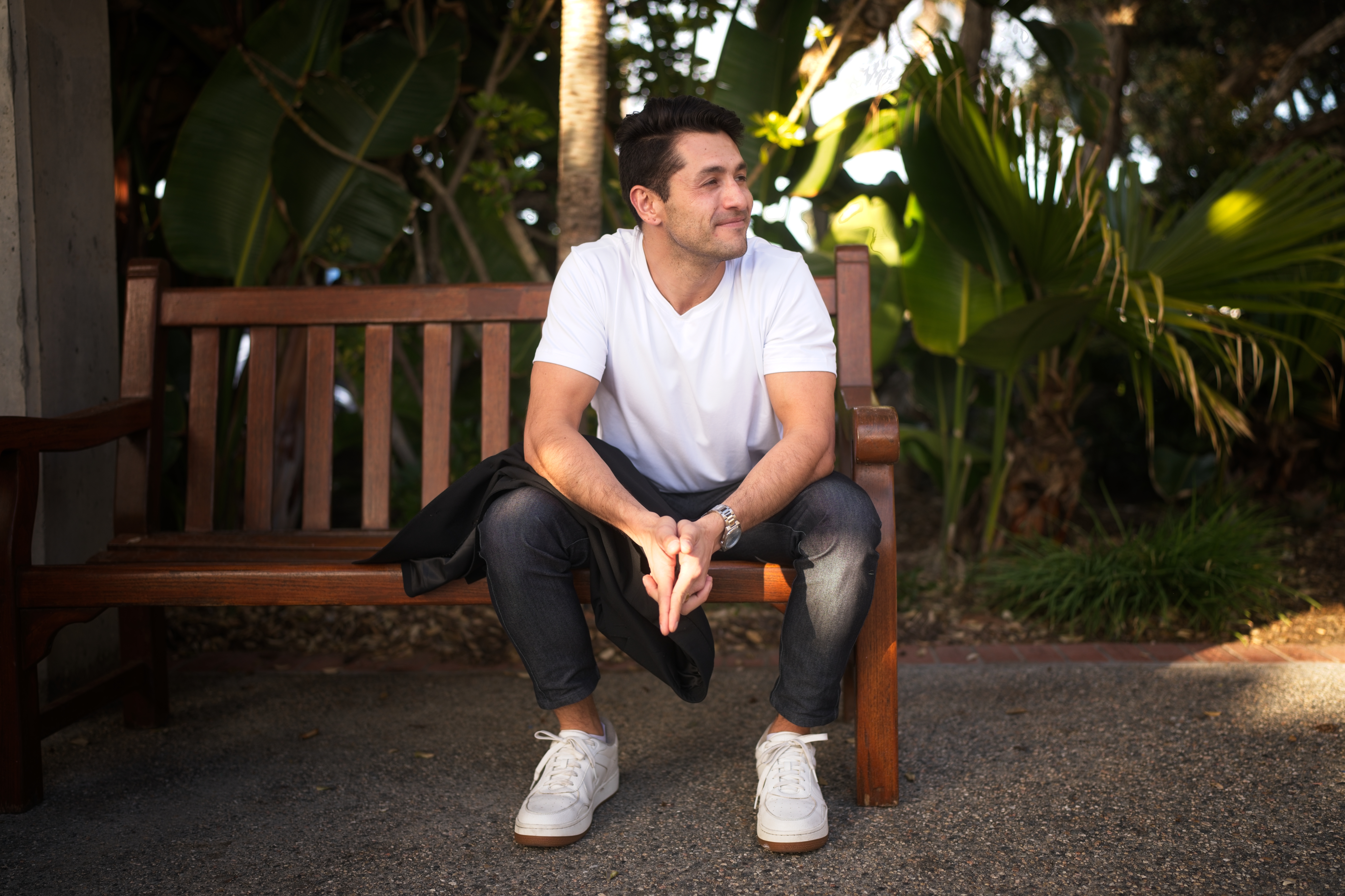 Man sitting alone on a bench reflecting—symbolizing emotional over-investment and anxious attachment dating patterns in early relationship stages.