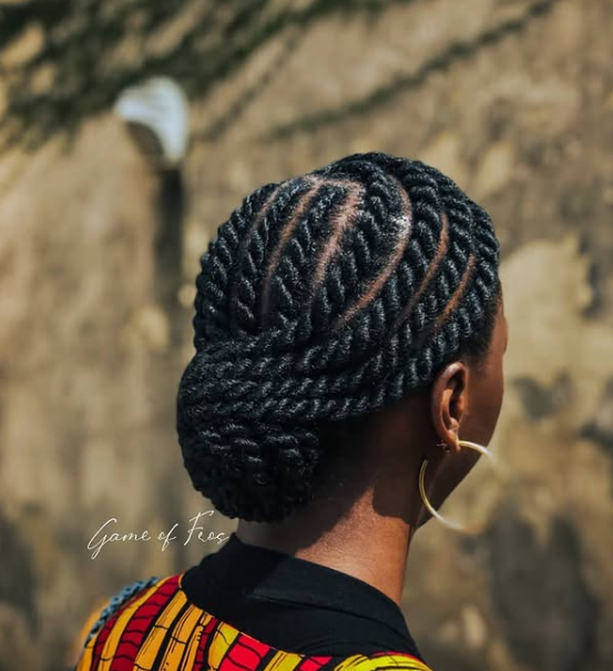 person with dark hair styled in flat twists