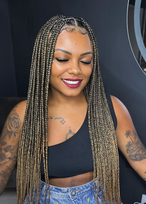 person with long, blonde-streaked box braids