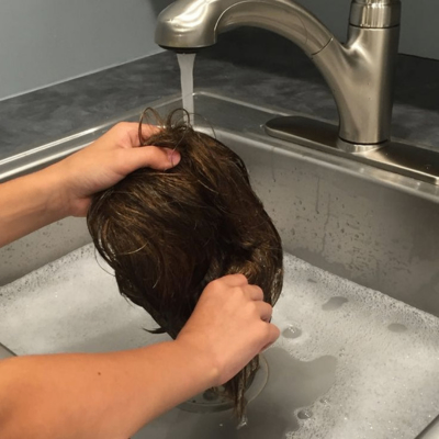 A person washing hair extension