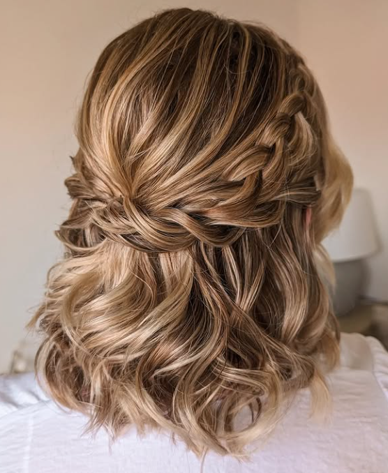 person's head showing blonde and brown highlighted wavy hair styled in a half-updo