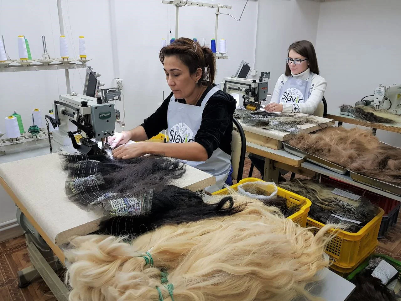 Two individuals working at sewing machines